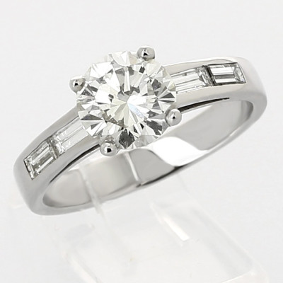 Solitaire or et diamants Lisa. Diamant central rond (brillant) et baguettes sur les côtés - or 18 carats.