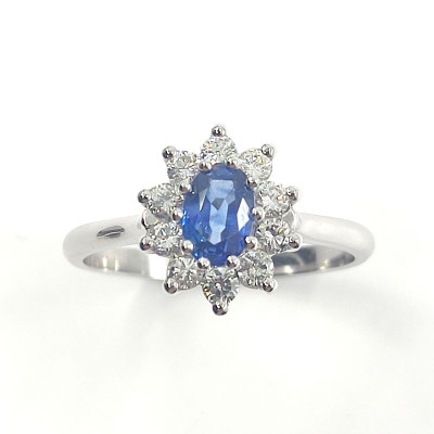 Bague saphir et diamants Naïa. Marguerite avec un saphir ovale de 0,63 ct et 0,40 ct de diamants - or 18 carats.