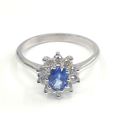 Bague saphir et diamants Naïa. Marguerite avec un saphir ovale de 0,63 ct et 0,40 ct de diamants - or 18 carats.